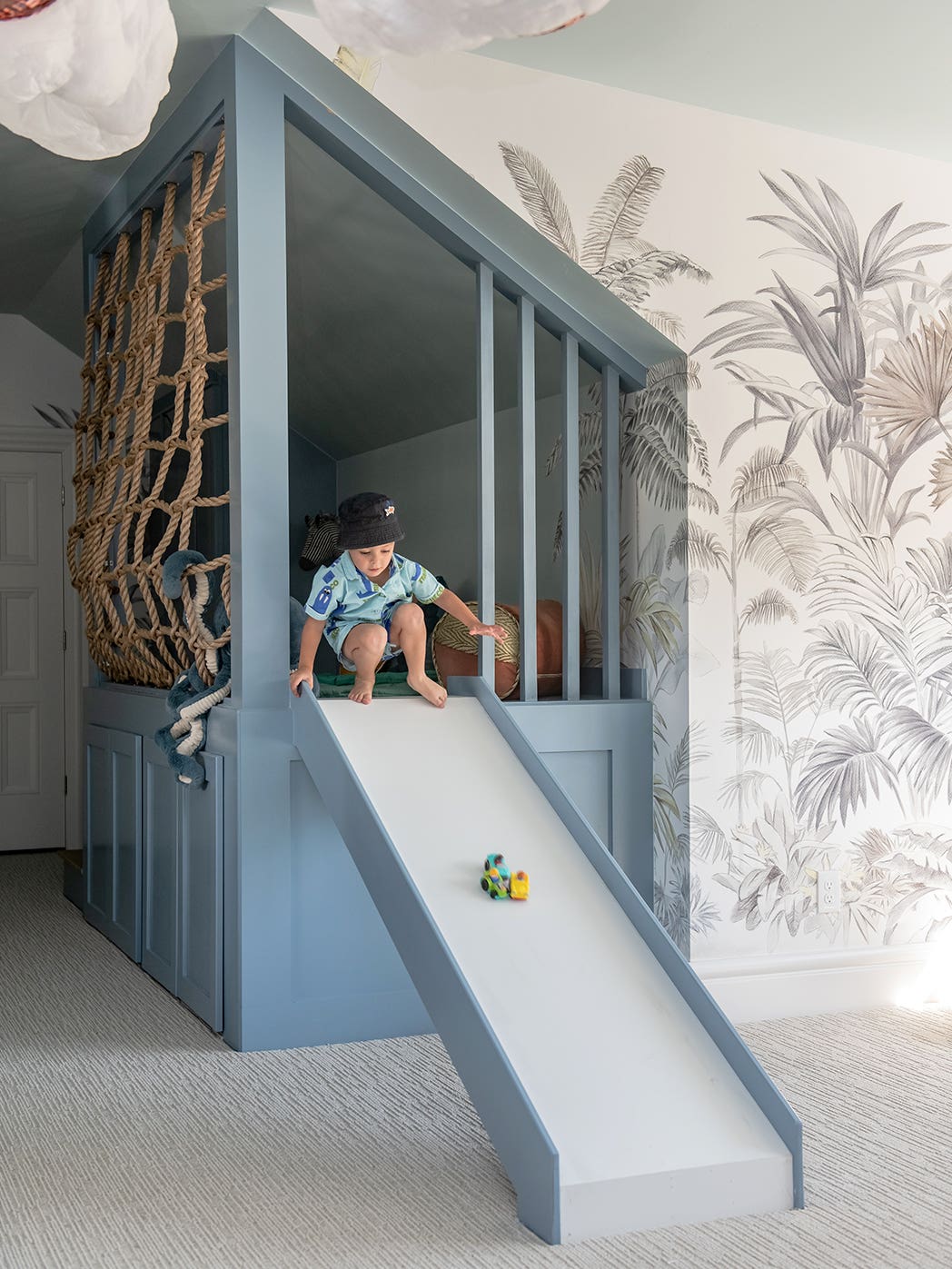 child going down blue indoor slide
