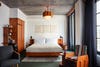 Hotel room with bed and wood lamp.