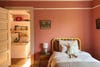Kids room with yellow bed and red patterned wallpaper. 