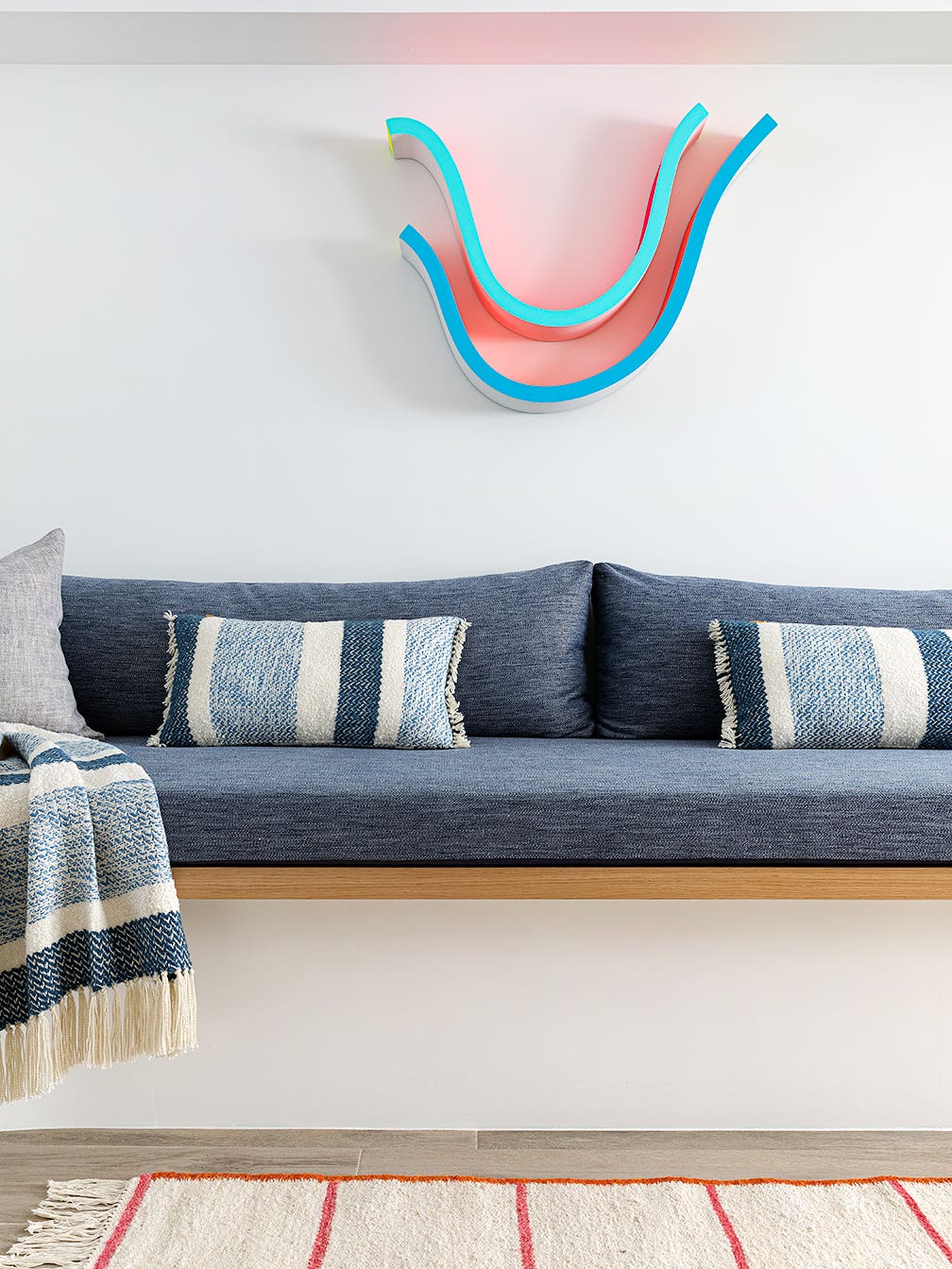 A Cool Wavy Sofa Conceals the Ductwork in This Family’s Brownstone Basement