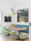 Green dining chairs with yellow cushions around wood table and breakfast nook