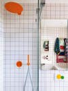 White-tiled bathroom with bright, multi-color grout and fixtures.