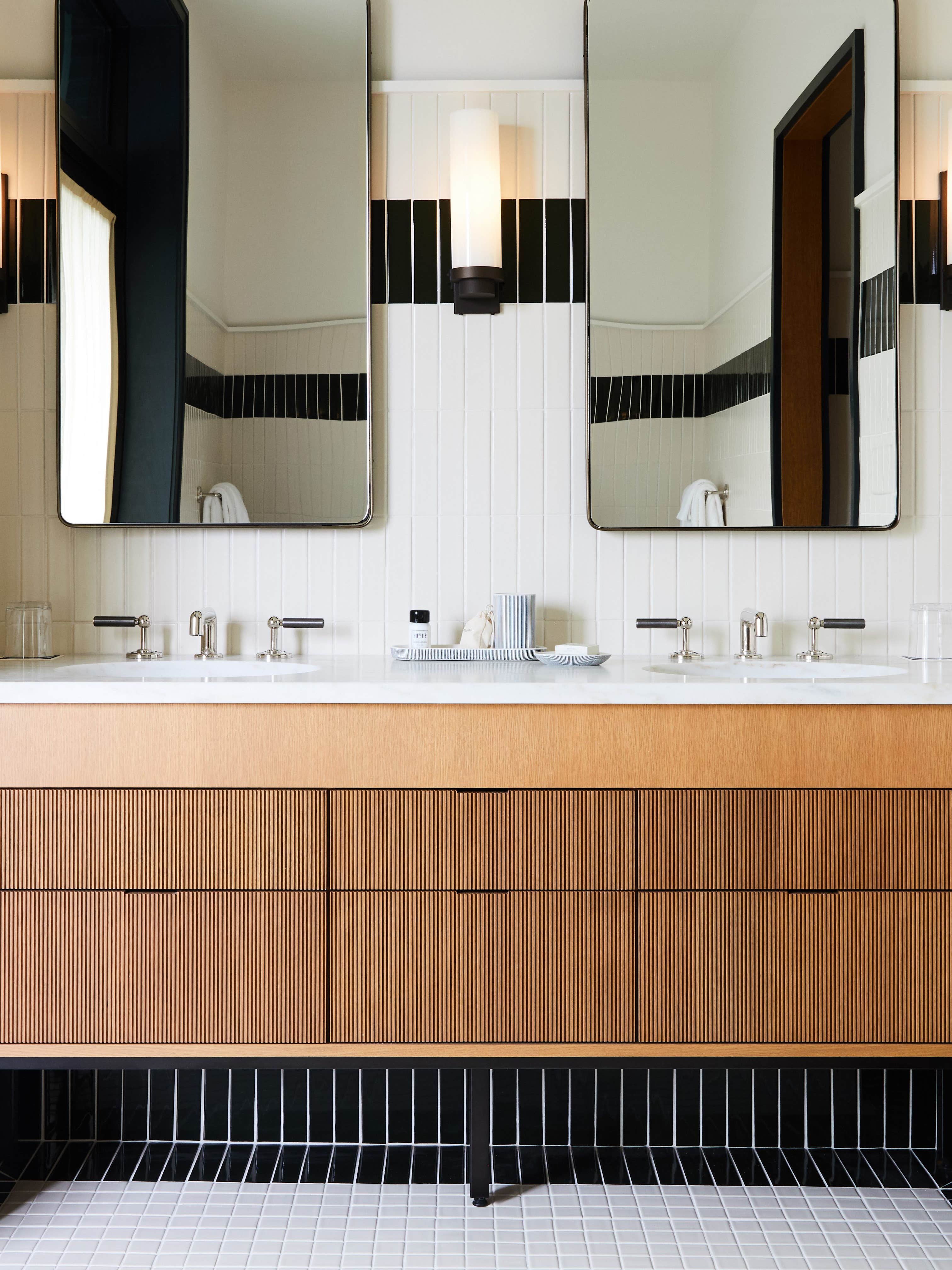 wood bathroom vanity surrounded by marble walls and counter