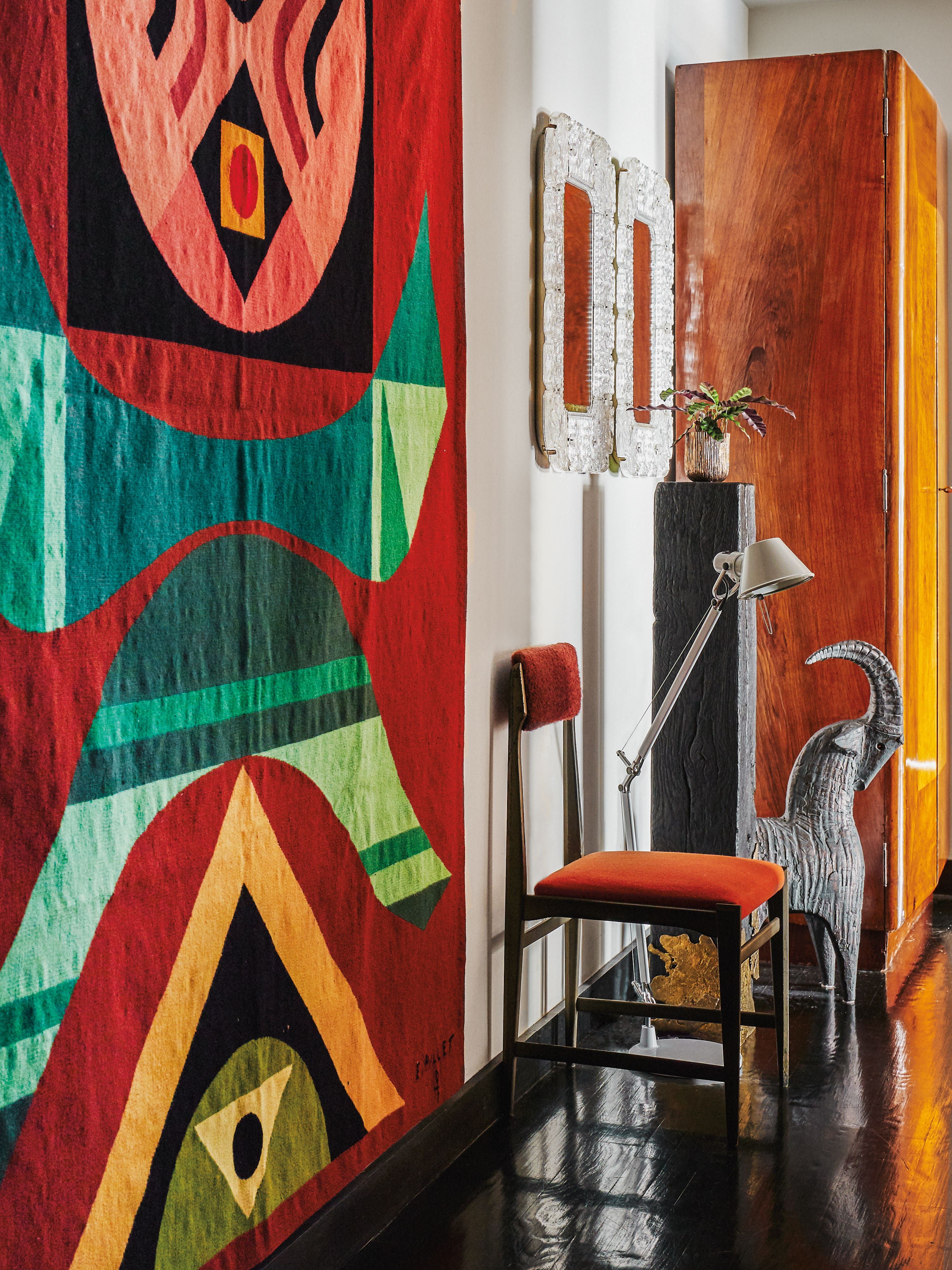 colorful quilt on wall next to orange chair