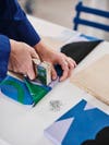 Person stapling fabric to a board