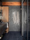 Bathroom with black textured wall and wood trim.