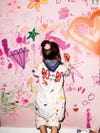 Little girl drawing on a pink wall