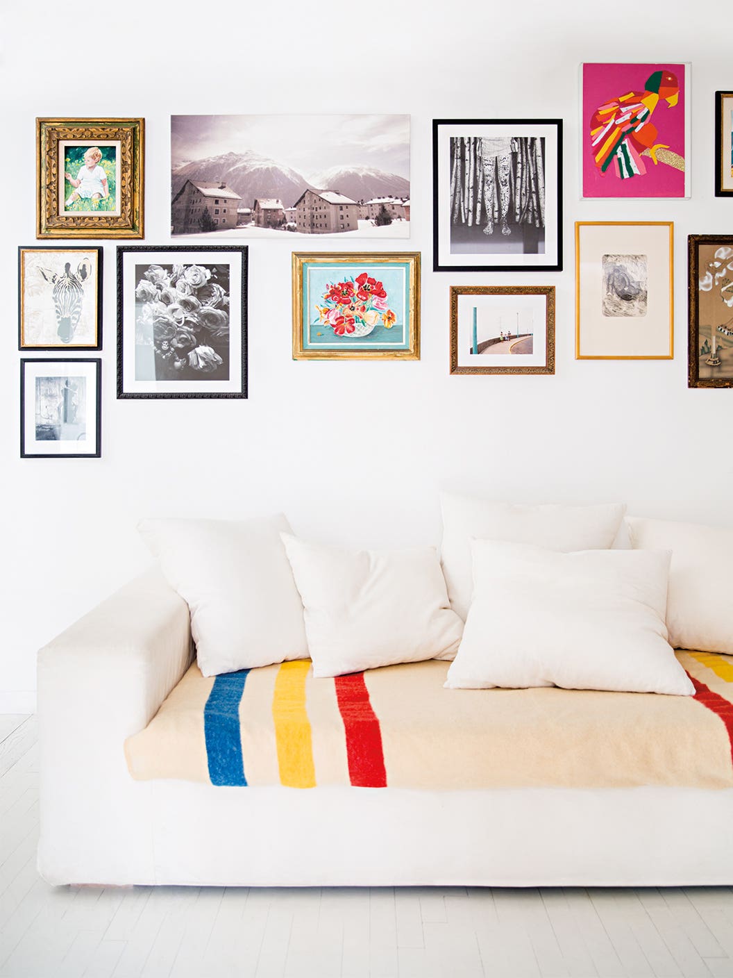 white sofa with bottom cushion covered in blanket