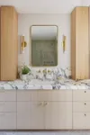 Bathroom with beige vanity, marble countertop, and wood storage cabinets on the sides.