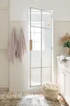All-white bathroom with metal and glass shower door. 